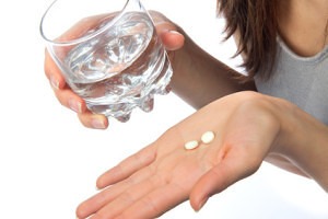 image of woman holding aspirin 