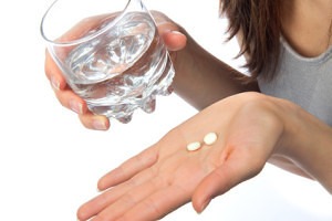 image of woman holding aspirin